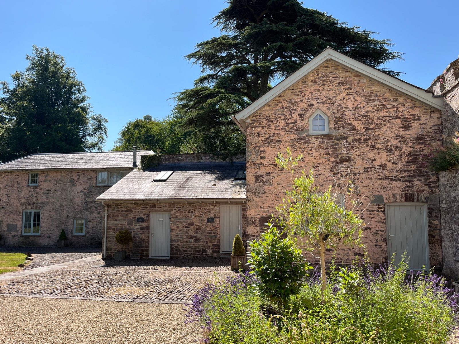 The inner courtyard of the Ty Mawr Collection framed by lavender and stone barns
