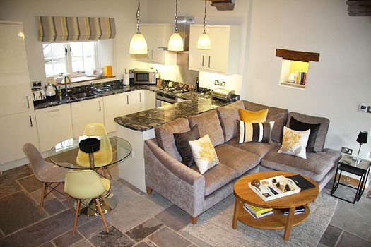 Downstairs living and kitchen space at The Laundry with corner sofa, dining area and fully equipped kitchen