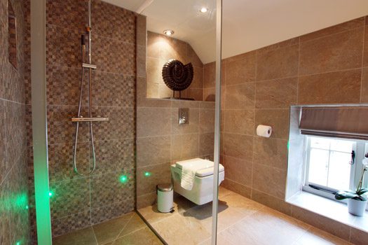 Modern walk-in shower at The Bothy with mosaic tiling and stone-tiled bathroom