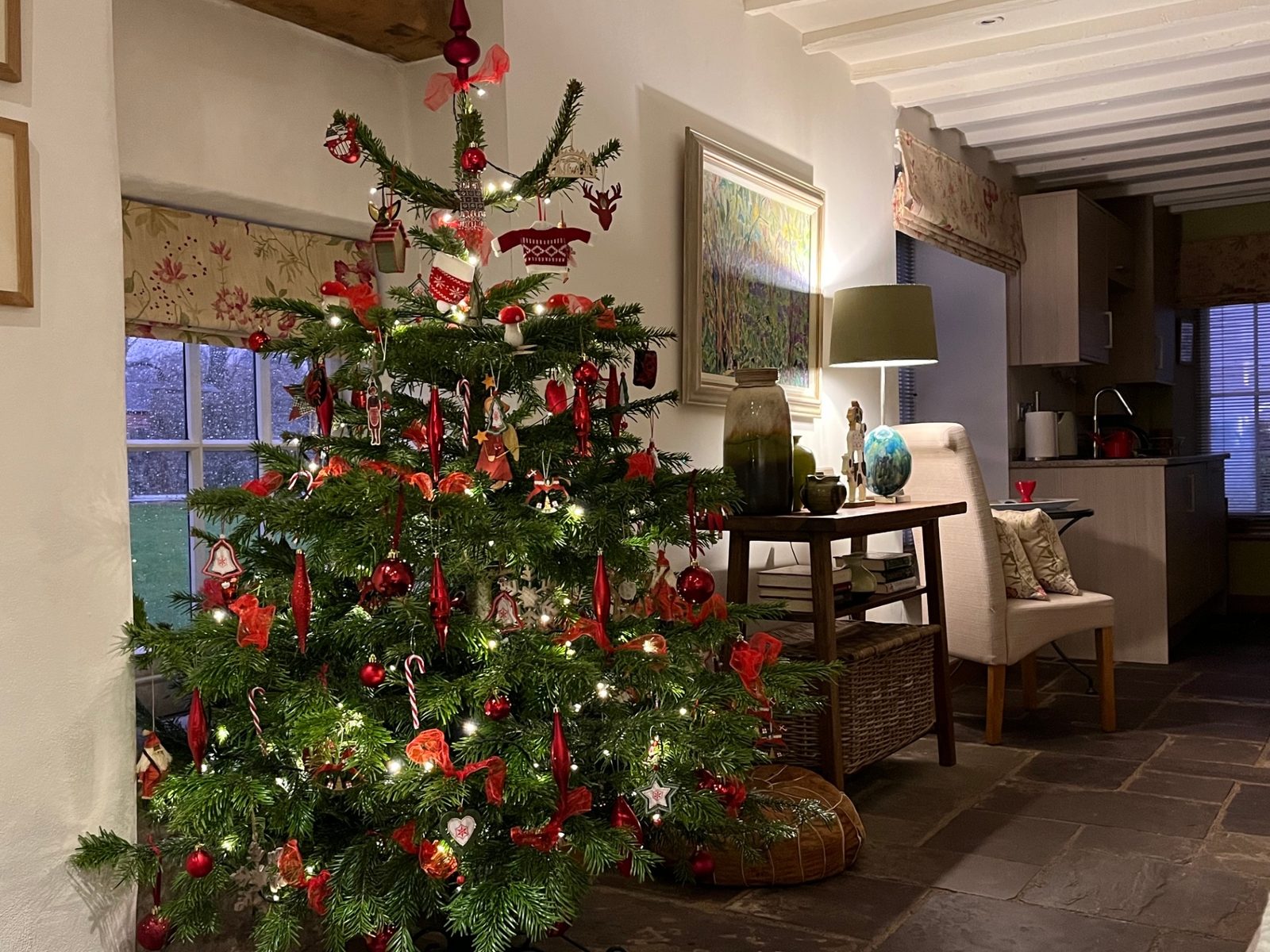 A traditionally decorated red and gold Christmas tree in the beamed sitting room of The Dairy at Ty Mawr